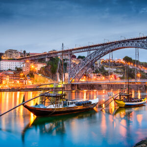 Porto, Portugal old town skyline on the Douro River with rabelo boats.